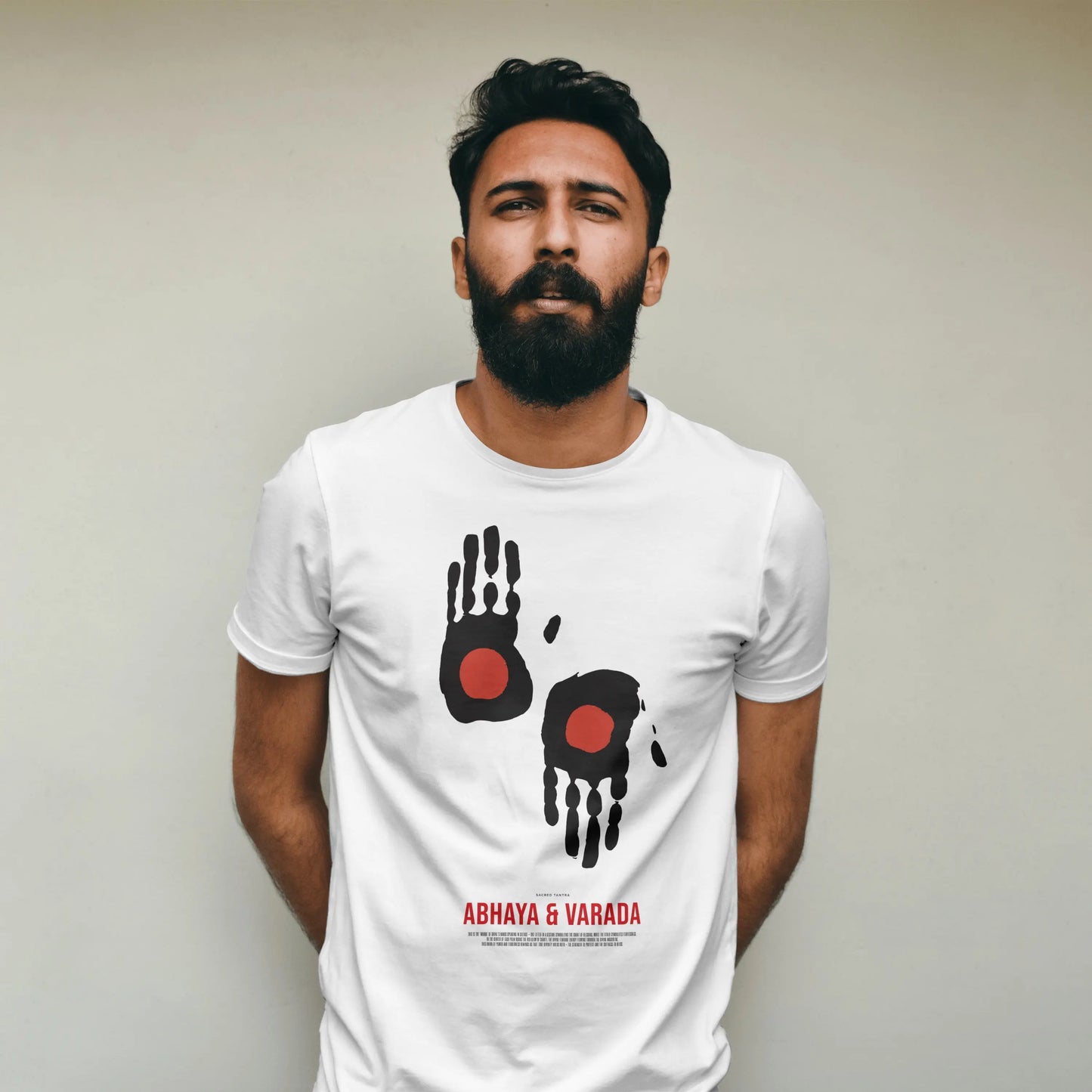 Man wearing a white t-shirt with black and red handprint design and text on a plain background