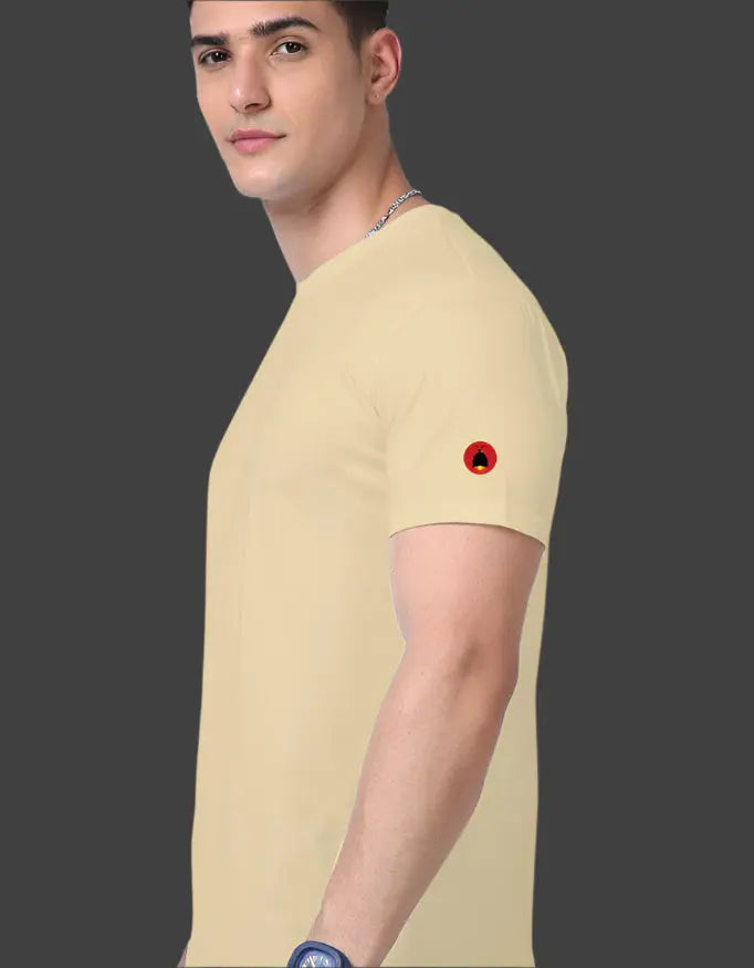 Man wearing a beige t-shirt with a red and black logo on a dark background