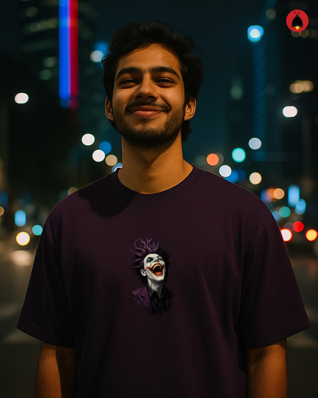 Man wearing a dark t-shirt with a graphic design, standing against a blurred cityscape at night.