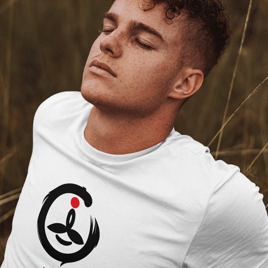 Man wearing a white t-shirt with a black and red logo in a natural setting